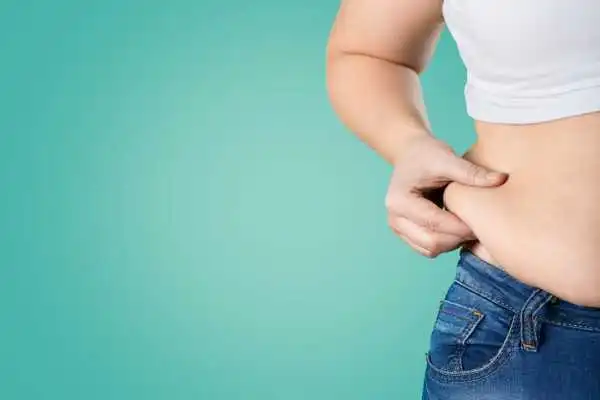 Image of woman pinching her love handles to show weight gain Littlehampton